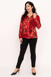 Front view of a woman in a red floral tailored blouse with black trousers