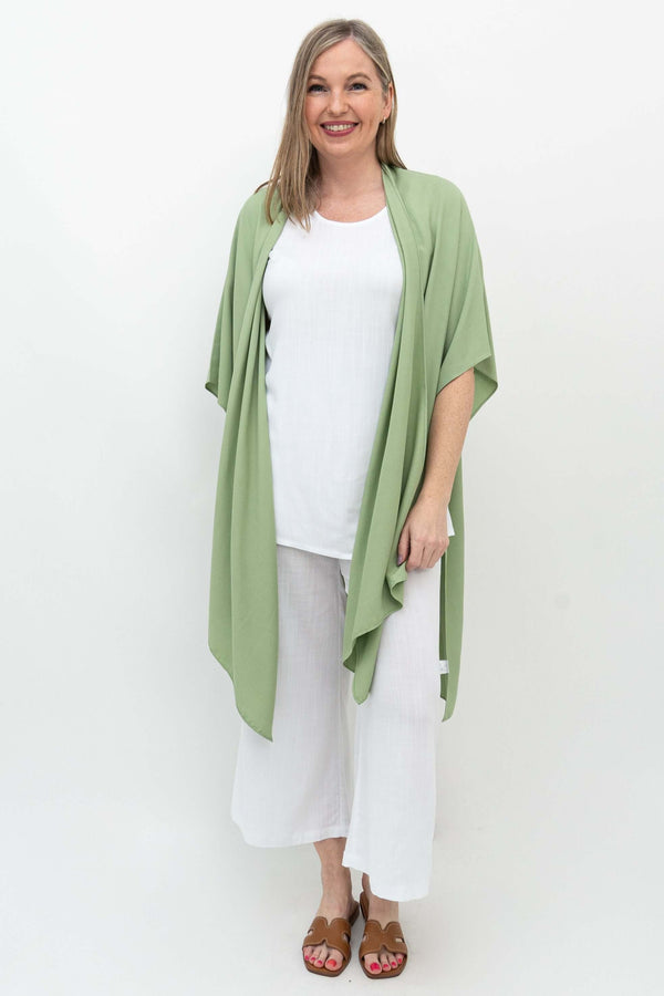 Front view of woman wearing a light sage green kimono wrap over white outfit