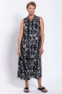 Front view of woman wearing a sleeveless black and white floral A-line dress
