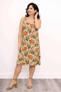Front view of woman wearing sleeveless floral knee-length dress with scoop neckline