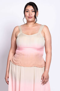 Front view of a woman wearing a sleeveless ombre maxi dress in beige, pink, and peach tones