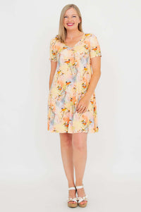 Woman wearing short-sleeved bamboo dress with pastel bird print, front view