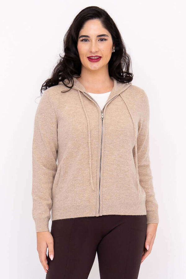 Woman wearing a beige zip-front hoodie with hood down, front view