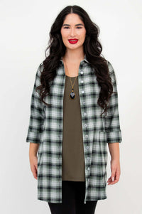 Woman wearing a green plaid flannel tunic shirt over an olive green top, front view