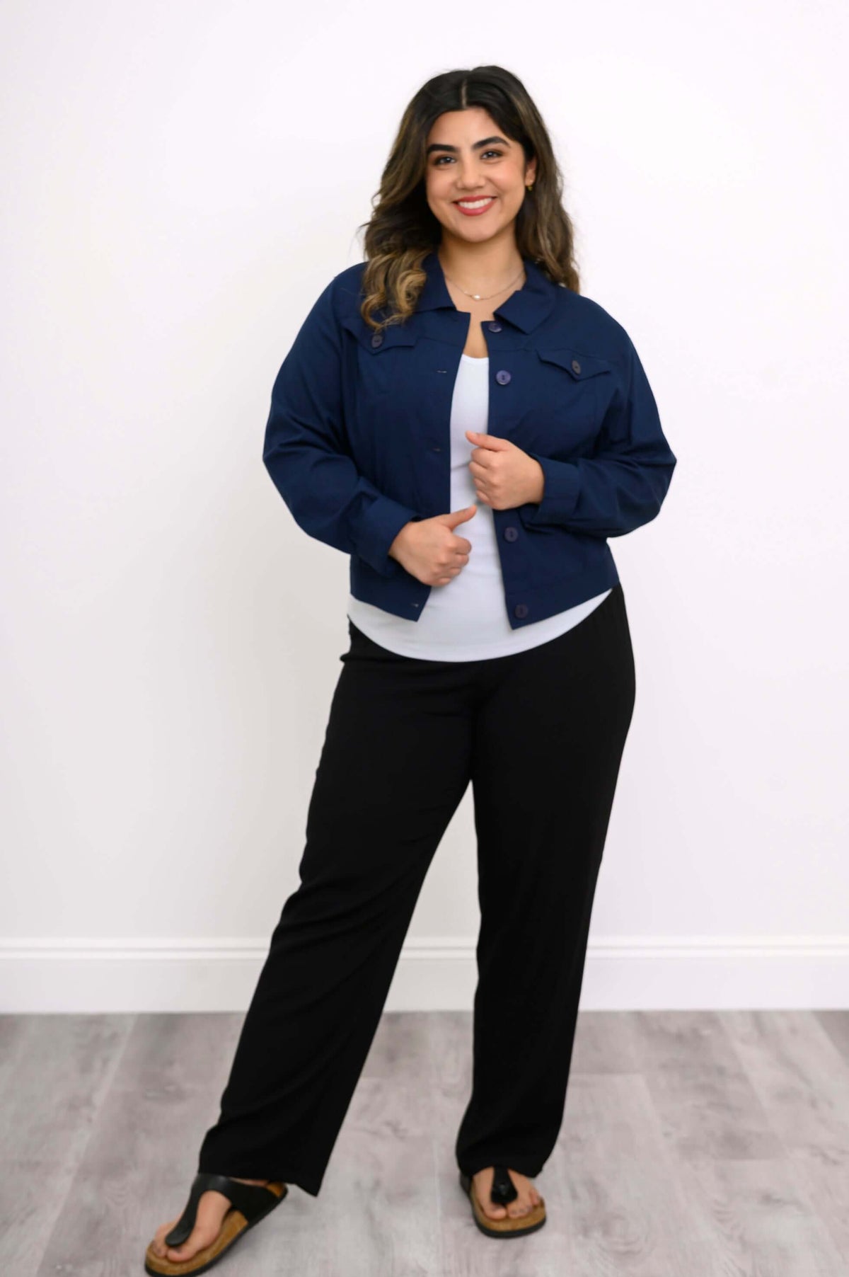 Woman in navy blue jean jacket, arms relaxed, showing front view