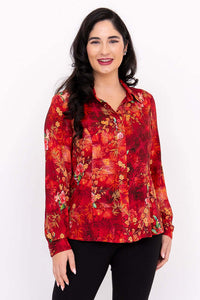 Woman wearing a vibrant red floral tailored blouse with long sleeves, front view