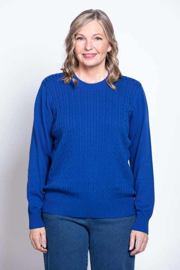 Woman wearing a royal blue cable knit cotton sweater with crew neck, front view