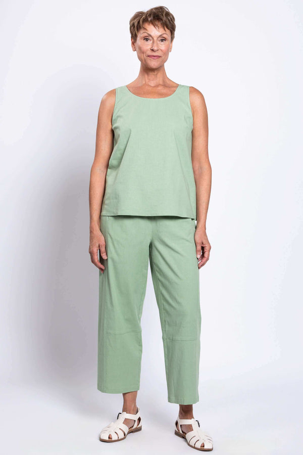 Woman standing in sage green cropped linen pants and matching sleeveless top, facing forward