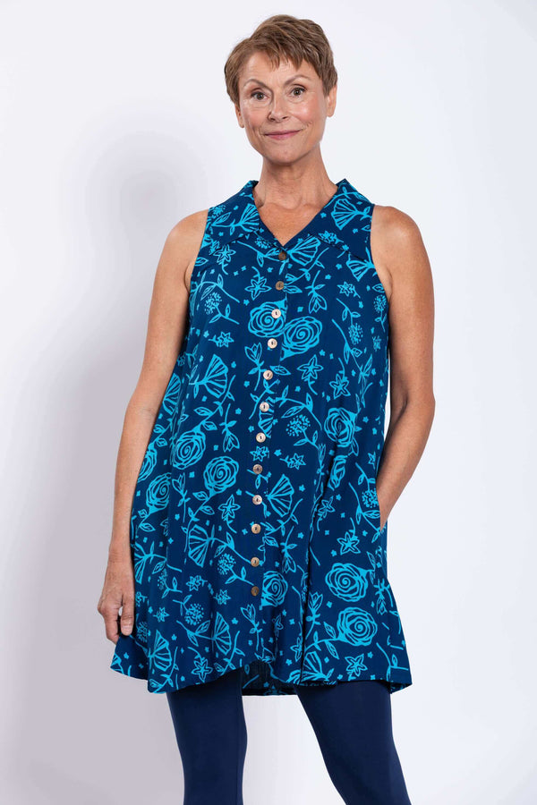 Front view of woman wearing a sleeveless blue A-line tank dress with button-up closure and floral pattern