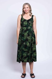 Front view of a woman modeling a green leaf print empire waist midi dress