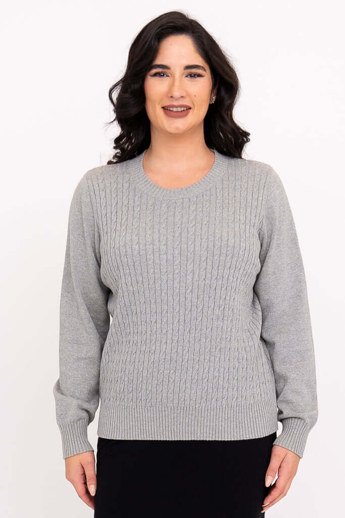 Front view of woman wearing a light grey cable knit sweater