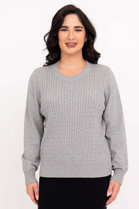 Front view of woman wearing a light grey cable knit sweater