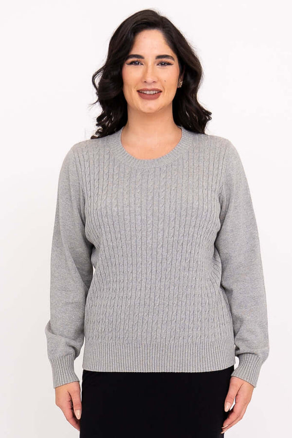 Front view of woman wearing a light grey cable knit sweater