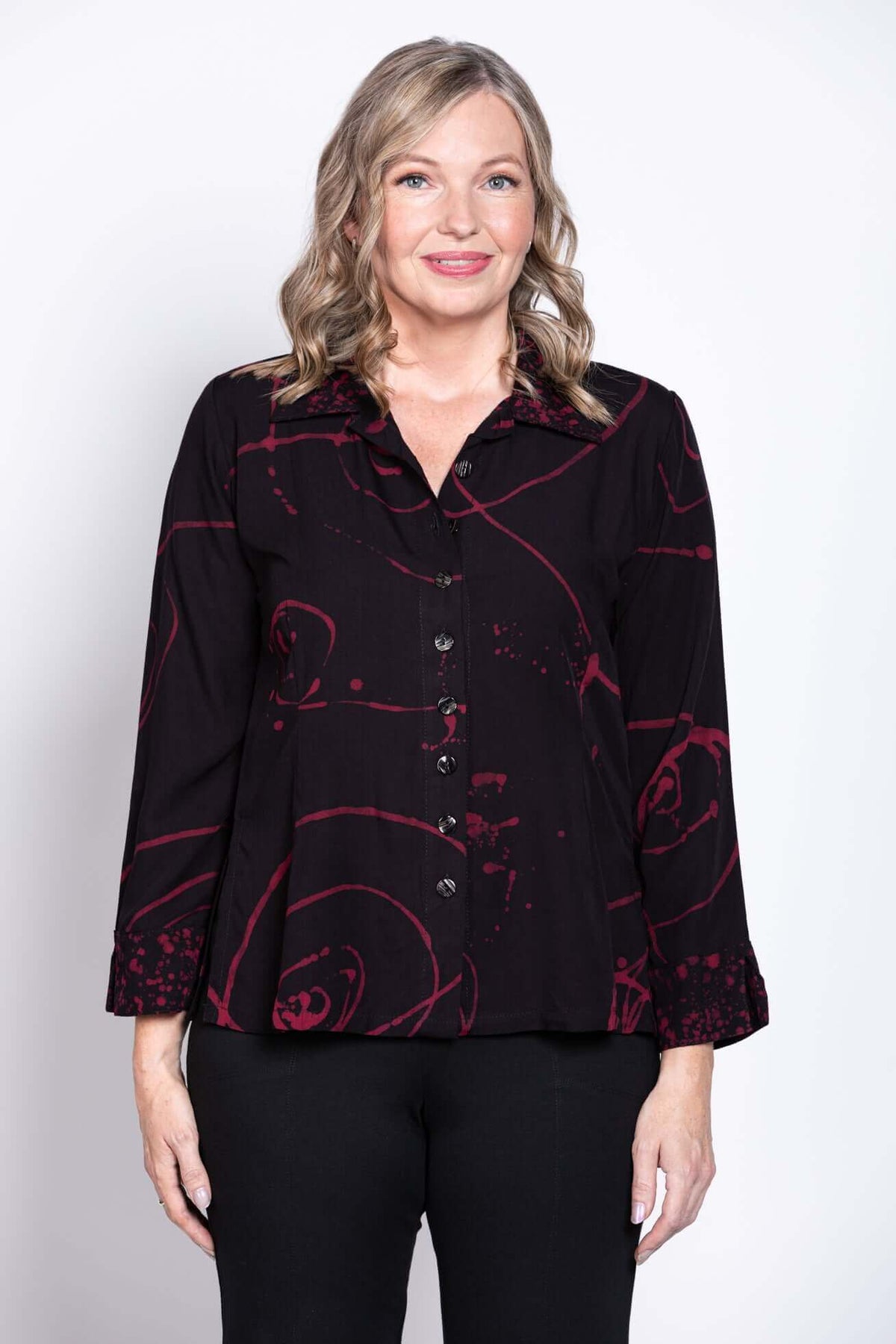 Front view of woman wearing black Ketut blouse with red abstract print