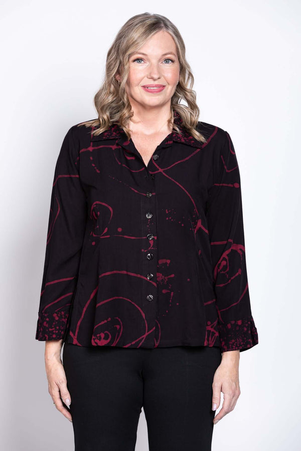 Front view of woman wearing black Ketut blouse with red abstract print
