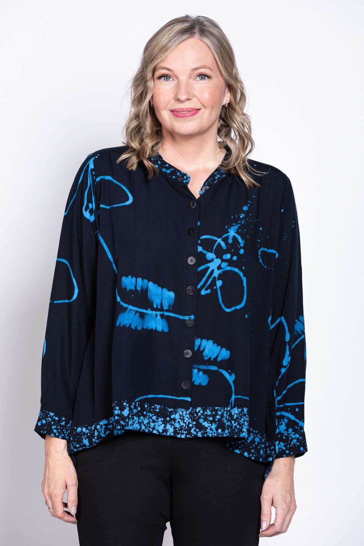 Front view of woman wearing a black blouse with blue batik print and mandarin collar