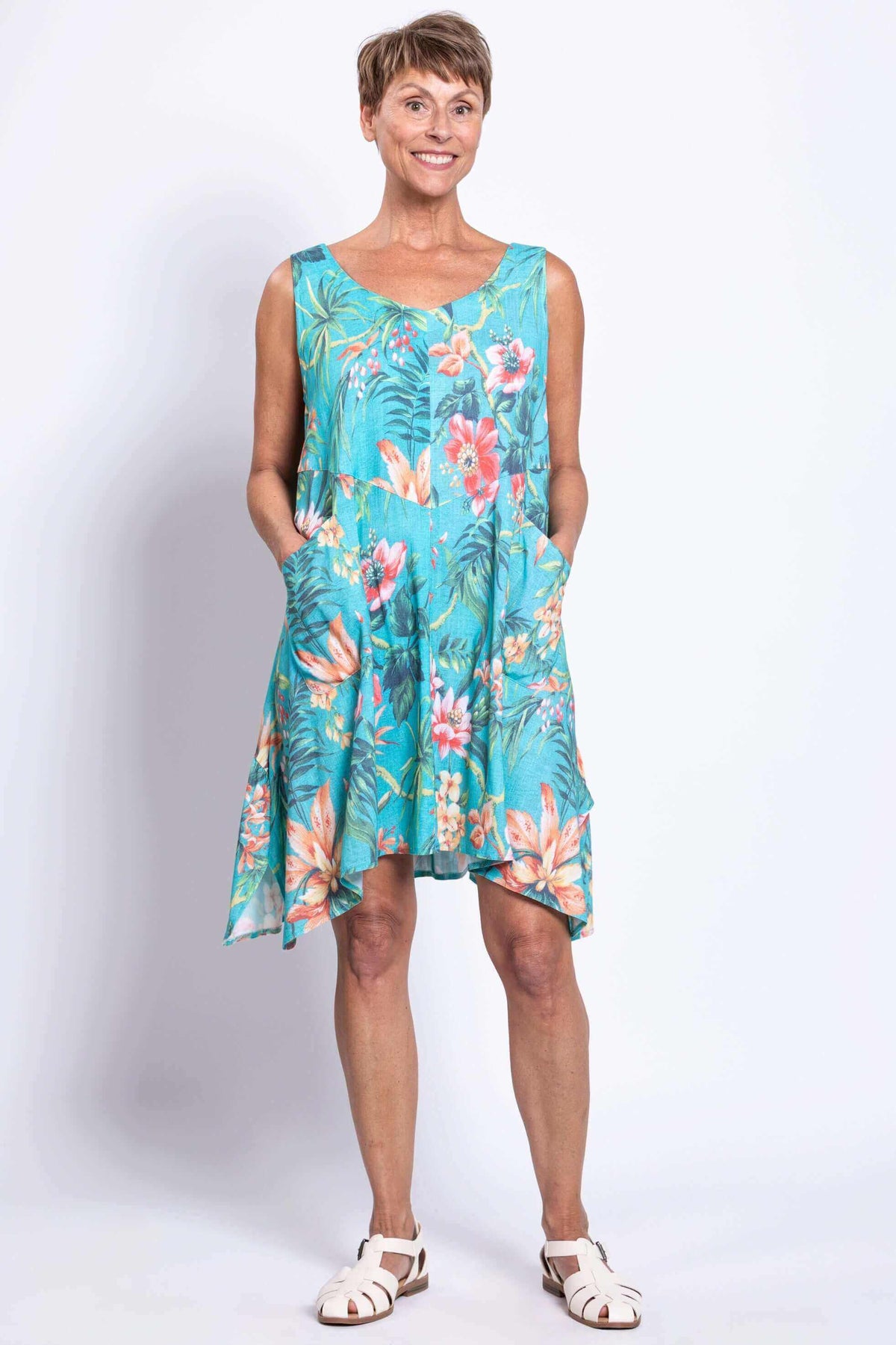 Front view of woman wearing blue floral sleeveless Gia Dress with pockets