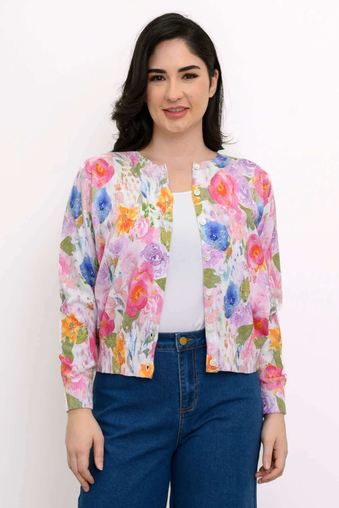 Front view of a woman modeling a pastel floral cardigan over a white top and blue jeans