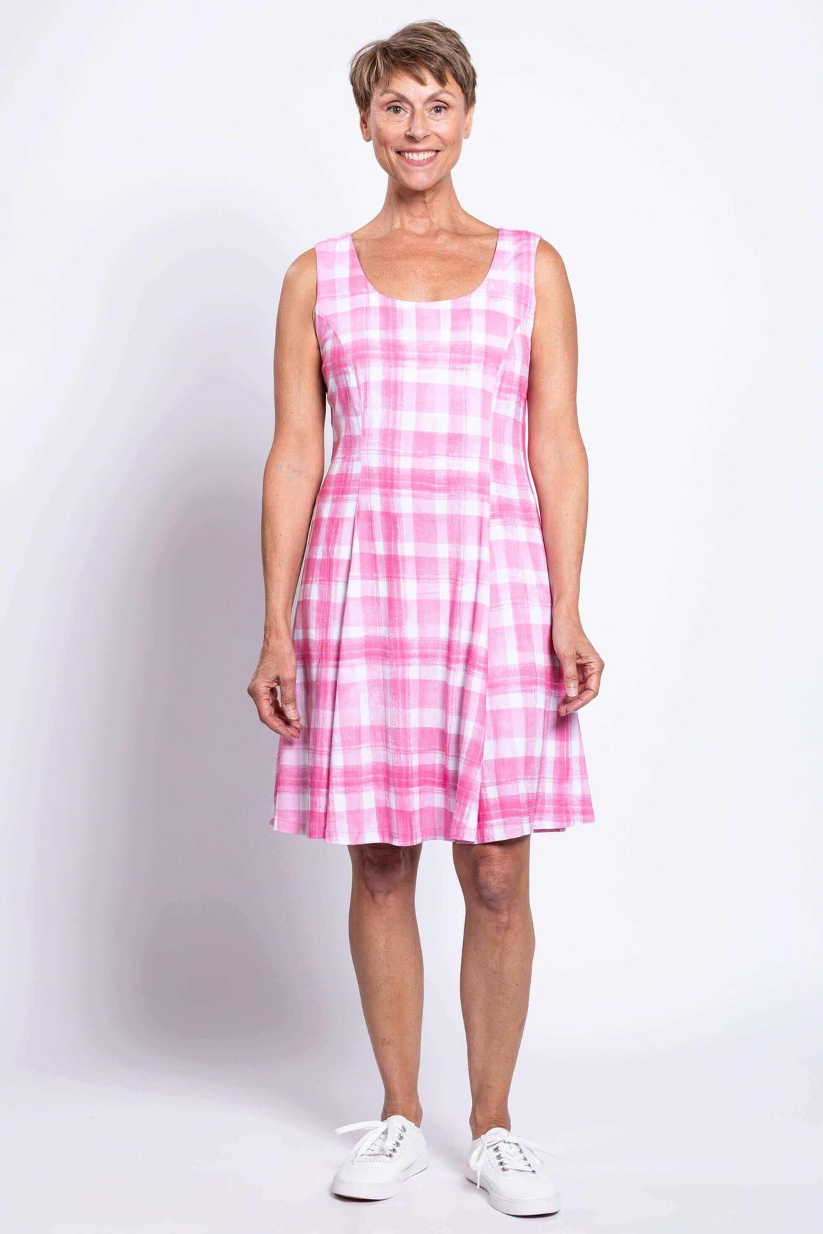 Front view of woman wearing sleeveless pink plaid A-line dress with scoop neckline