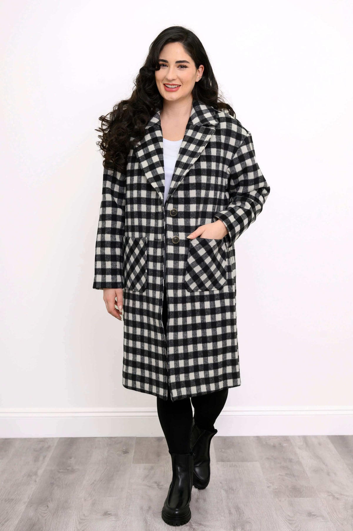 Front walking view of woman in black and white check print long coat