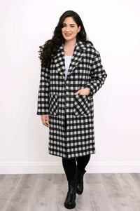 Front walking view of woman in black and white check print long coat