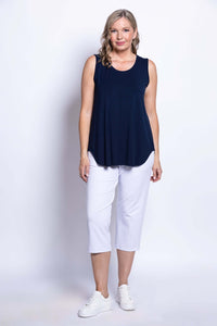 Woman modeling a navy sleeveless tank top and white pants, frontal pose