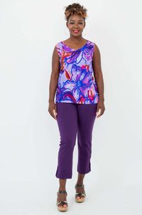 Full-body front view of a woman in a floral V-neck tank and purple pants