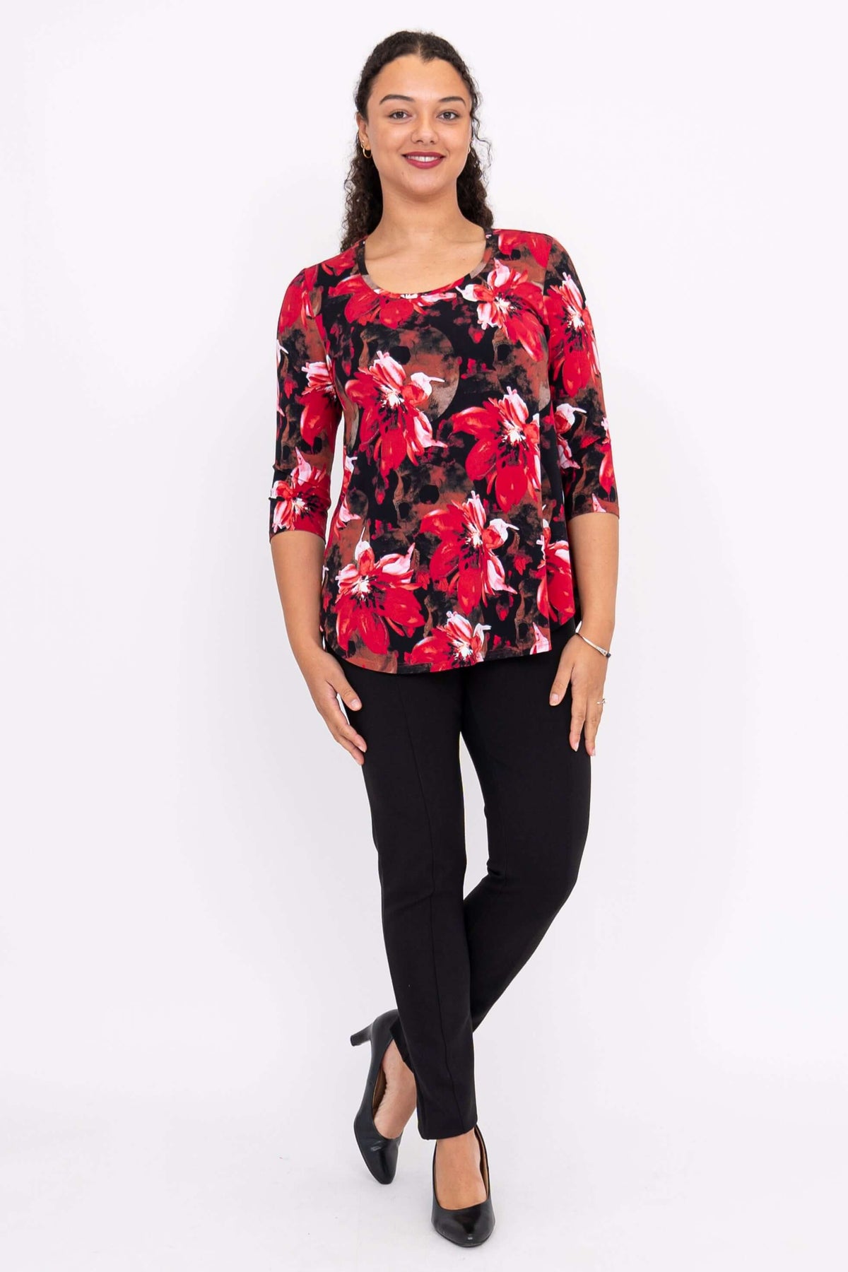 Front full-body view of a model in a red floral bamboo top and black trousers