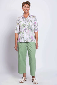 Full-body front view of woman in Lorine floral blouse and green pants