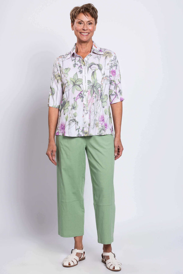 Full-body front view of woman in Lorine floral blouse and green pants