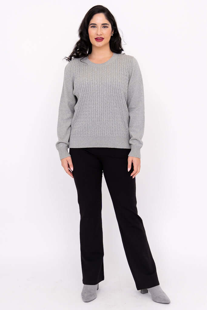 Full-body front view of woman in grey sweater and black pants