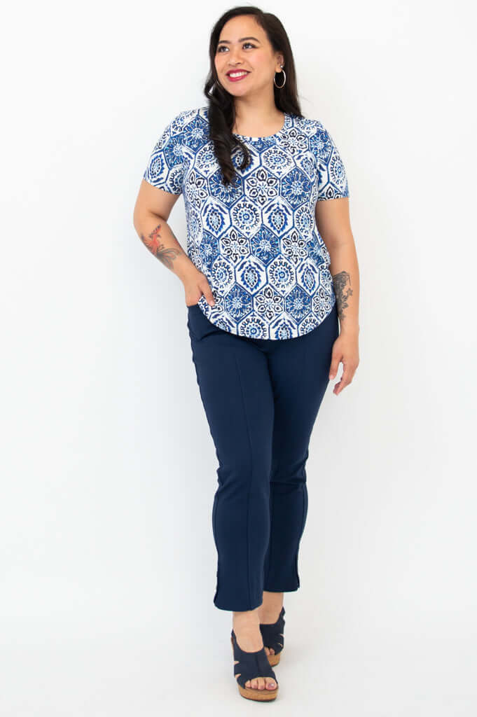 Full-body view of woman in blue mosaic Tessa Tee and navy pants with sandals