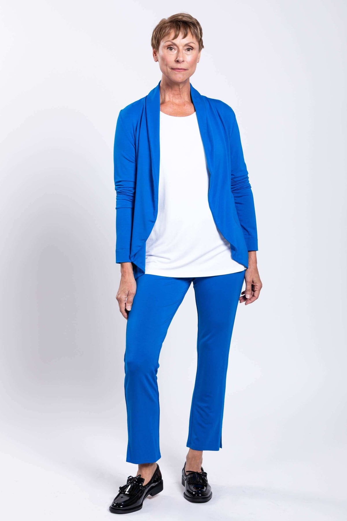 Full-body view of a woman in an azure blue French Terry jacket and pants, facing forward