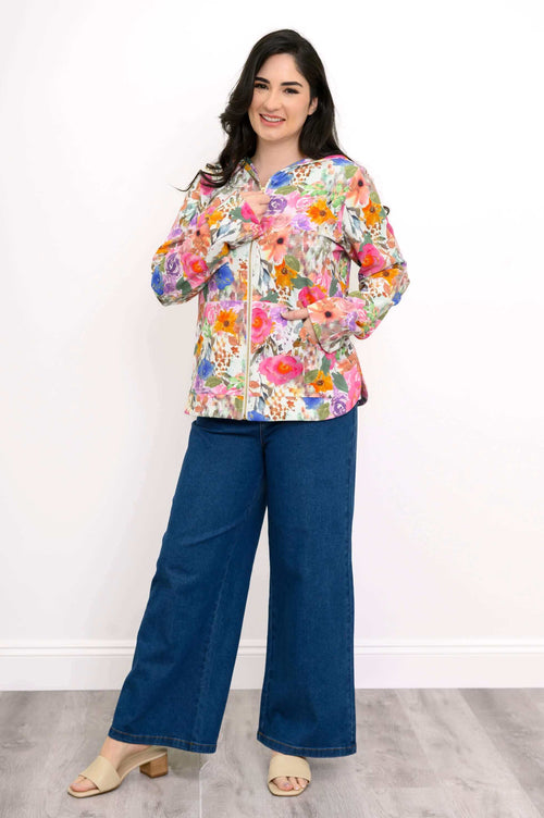 Woman modeling the floral zip jacket with hands in pockets, full-body front view