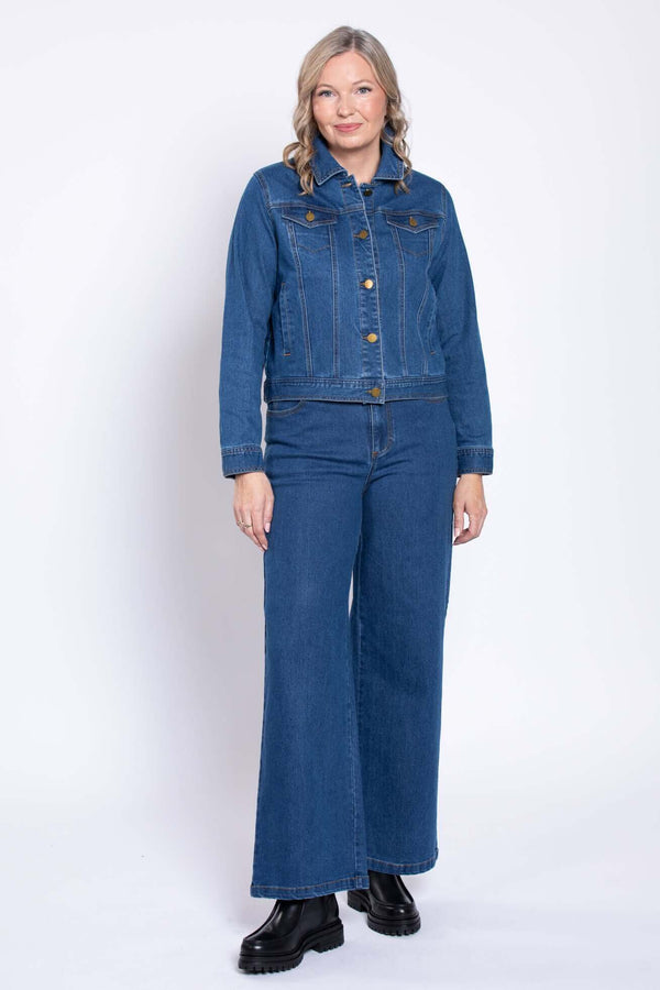 Woman standing and modeling a full-length blue denim jean jacket and pants