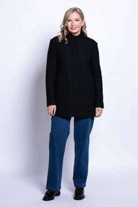 Full-length front view of woman in black boiled wool coat and blue jeans