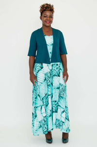 Full-length view of model wearing teal cropped jacket and blue maxi dress