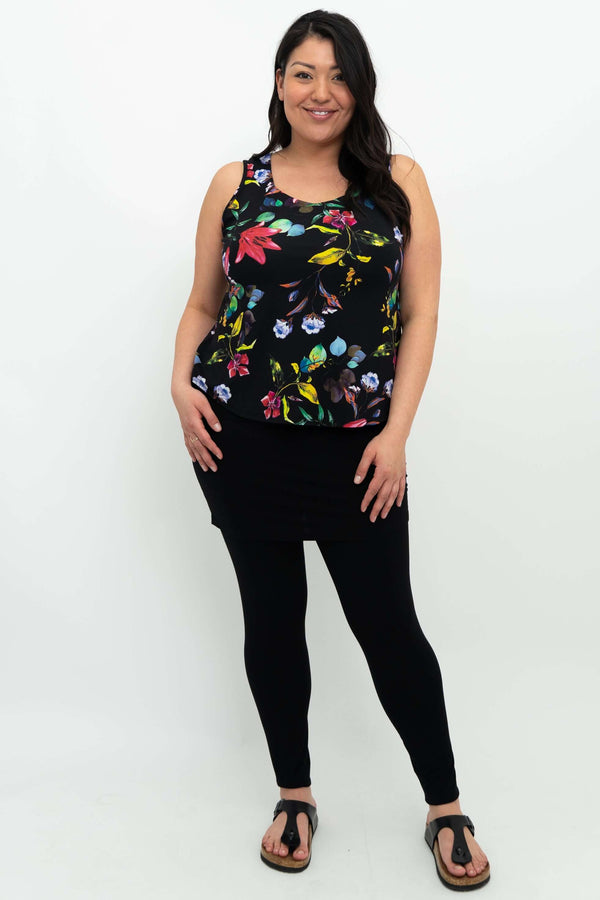 Full-length view of woman in black floral tank top paired with black leggings and sandals