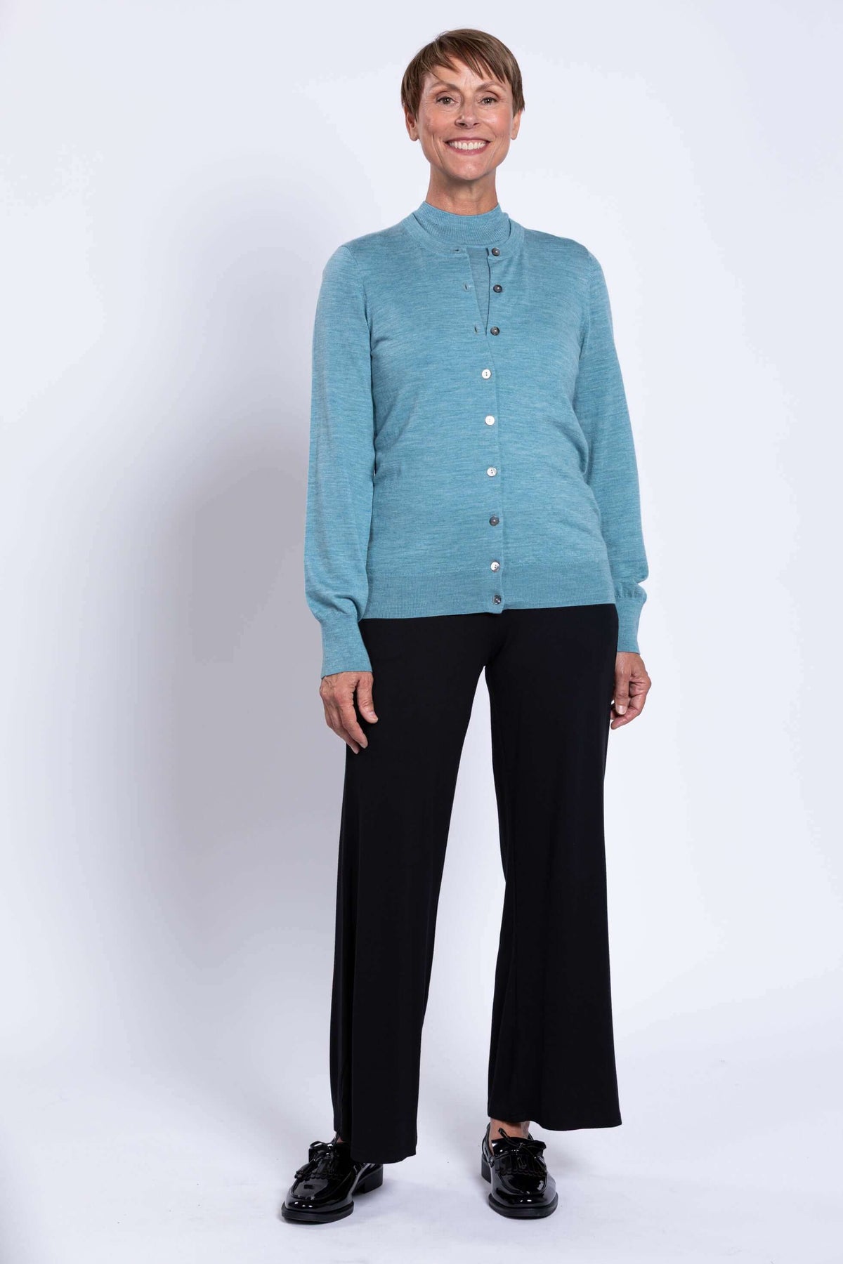 Full-length view of older woman in blue Kitten Cardigan and black pants