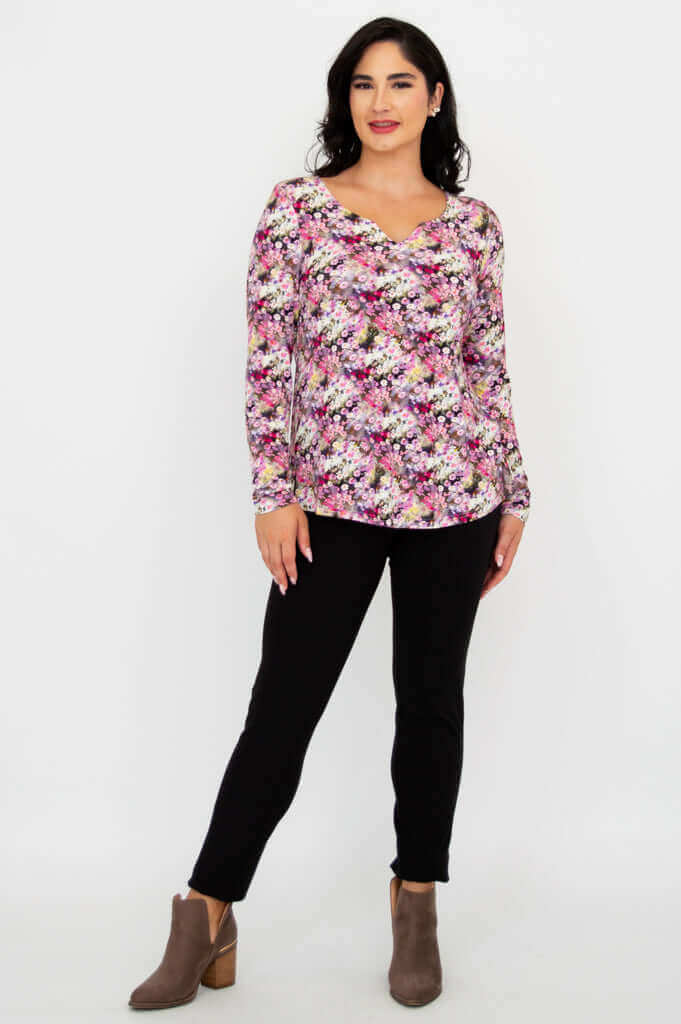 Full body front view of woman in floral long sleeve bamboo top and black pants
