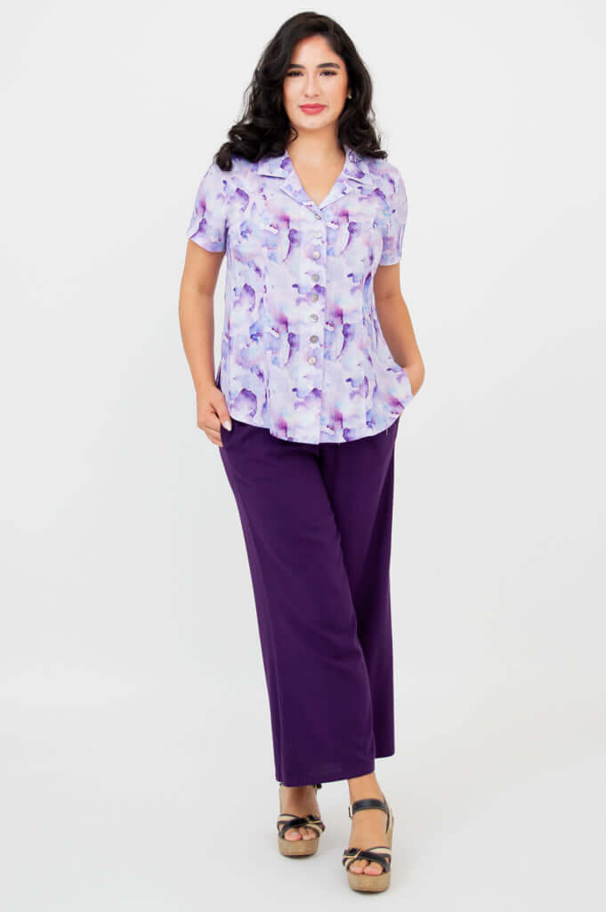Full body view of woman in purple watercolor shirt and wide leg purple pants