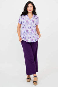 Full body view of woman in purple watercolor shirt and wide leg purple pants