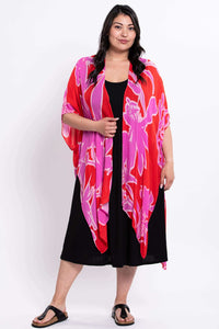 Full body view of a woman modeling a pink and red floral kimono wrap and black dress
