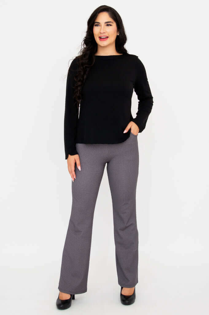 Full body front view of woman in black Mona boat neck top and grey check pants