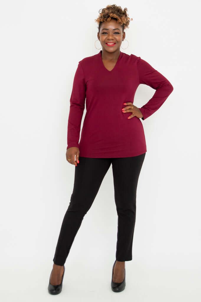 Full front pose of woman in burgundy V-neck bamboo top and black pants