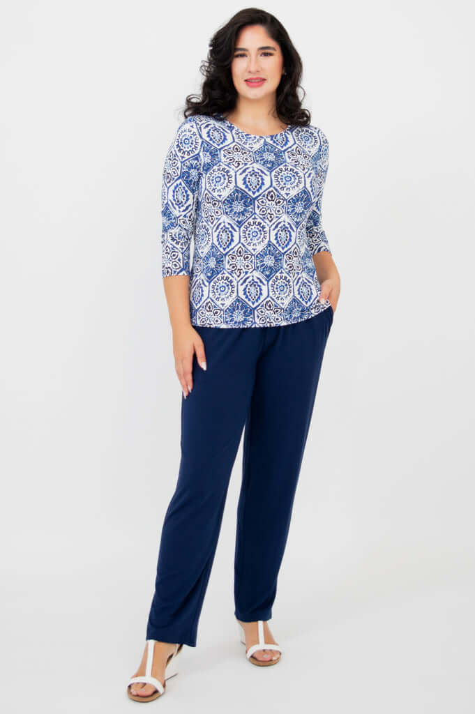 Full body front view of woman in blue mosaic tee and navy pants