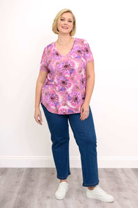 Plus size model in floral v-neck top and jeans, full body front view