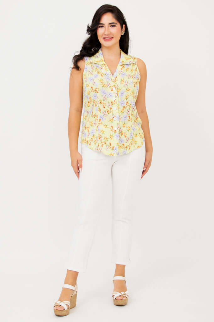 Full front view of model in yellow floral sleeveless shirt and white pants