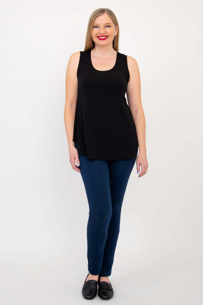 Full front view of woman in black tank top and blue pants