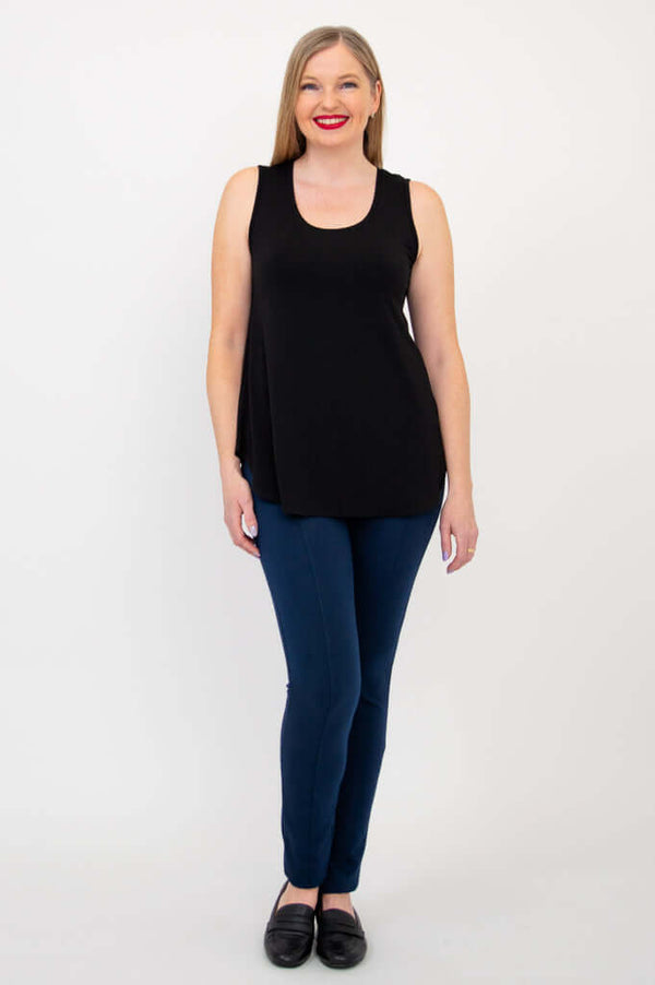 Full front view of woman in black tank top and blue pants